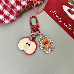 Detailed view of gingerbread man and red apple charms on a festive Christmas keychain
