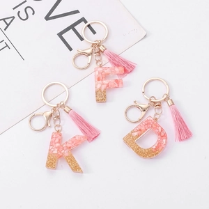 Pink resin alphabet keychain with gold foil flakes and matching fiber tassels