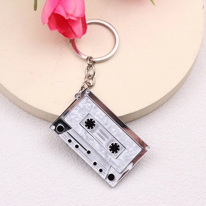 Macro shot of silver metal cassette tape keychain with white mother-of-pearl inlay