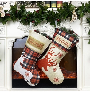 Gros plan de chaussettes de Noël rustiques avec motifs de renne sur une cheminée douillette