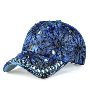 Detail of floral lace pattern with luxury rhinestone crystals on blue baseball cap