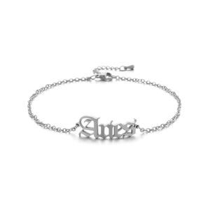 Macro shot of silver Aries zodiac anklet with old English font pendant and lobster clasp