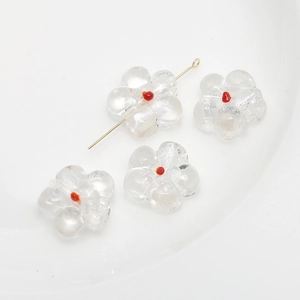 Detailed view of clear glass flower beads with red centers for DIY jewelry crafting