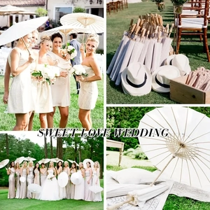 Set of white paper umbrellas with bamboo frames for outdoor wedding parties and photography