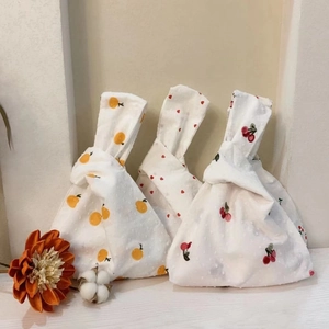 Detailed close-up of Japanese knot bags with orange, heart, and cherry patterns