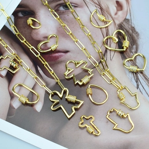 Détail de colliers chaîne trombone dorés avec pendentifs cœurs et étoiles sertis de zircons