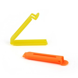 7cm matte plastic food sealing clips in yellow and orange colors on white background