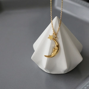 Minimalist 18K gold plated celestial necklace with moon and star pendants on a fine chain