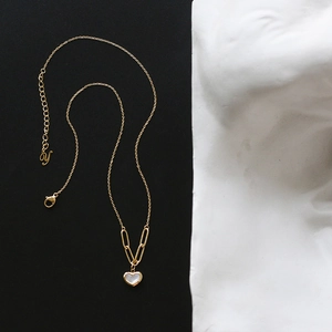 Detail of 18K gold-plated heart necklace featuring white mother-of-pearl inlay and Y tag