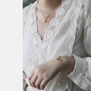 Detail of heart shell pendant necklace and bracelet set in 18K gold plated steel