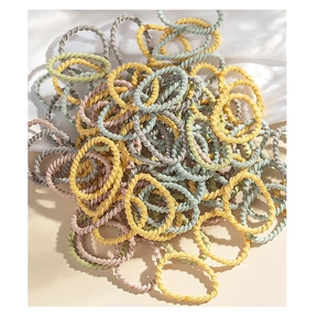 Detailed view of elastic spiral hair ties in pastel gray, blue, pink, and yellow colors