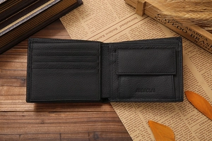 Short bi-fold men's leather wallet with card slots and coin pocket on vintage wood