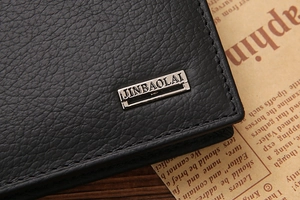 Close-up of black lychee grain leather wallet with neat stitching and metal logo