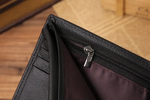Close-up of black leather wallet with card slots and a silver metal zipper detail