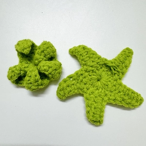 Handmade crochet accessories featuring grass green starfish and flower shapes in yarn