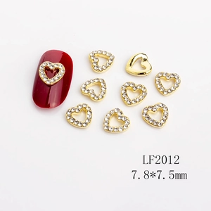 Macro detail of gold hollow heart nail gems with rhinestones and product dimensions