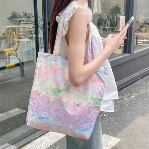 Floral canvas tote bag for women, large capacity shoulder bag shown in an outdoor street setting