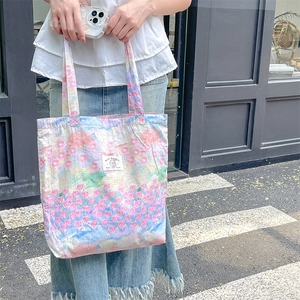Floral canvas tote bag with pleated fabric and My Rabbit logo carried by a model