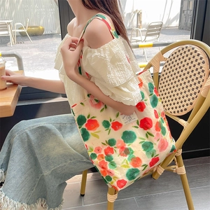 Close-up of floral canvas tote bag with red and green prints and Best Day Ever label