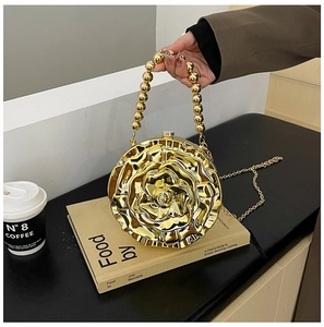 Detail of golden rose evening bag with beaded handle and metallic 3D floral texture