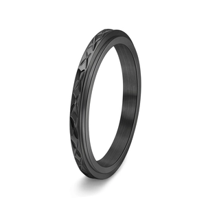 Close-up of a black rotating ring with cross star engraving and matte metal finish