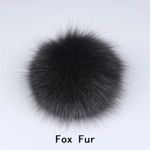 Macro shot of a fluffy black fox fur pompom for hats and accessories