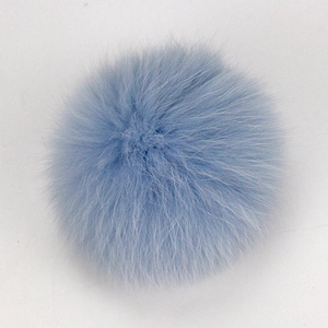 Detailed texture of light blue raccoon fur pom pom for hats and accessories
