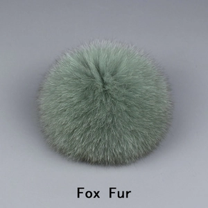 Macro shot of fluffy light green fox fur pom pom showing soft texture and natural hair detail