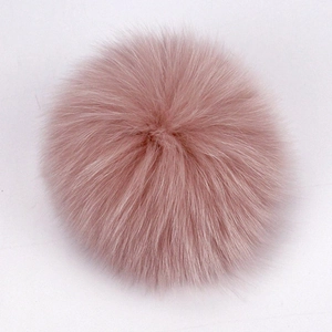 Close-up of soft pink real raccoon fur pompom accessory for hats and bags