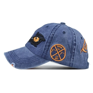 Washed navy blue baseball cap with cartoon eyes embroidery and vintage badges