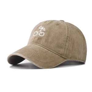 Detail of white cherry embroidery on a khaki washed cotton vintage baseball cap