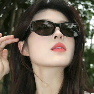 Chic black rectangle sunglasses with curved wide temples worn by model in outdoor light