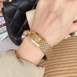 Elegant gold square watch with woven mesh strap worn by a model on a stylish background