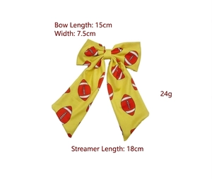Yellow rugby bow hairclip with streamers, measuring 15x7.5 cm with 18 cm tails