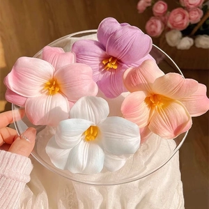 Realistic artificial tulip hair clips in various colors displayed on a clear plate
