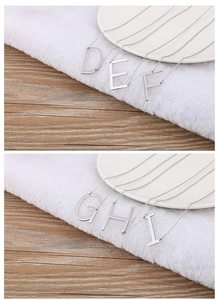 Detailed shot of silver uppercase letter pendants D to I on minimalist steel necklaces