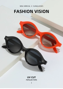 Détail de lunettes de soleil œil de chat montrant des montures épaisses noir mat et orange vif