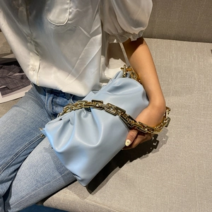 Light blue soft leather cloud bag with chunky gold chain strap shown on a model