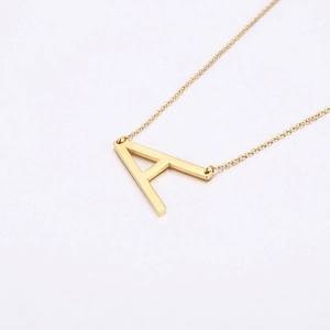 Collier avec pendentif lettre A en acier inoxydable doré poli sur fond blanc épuré