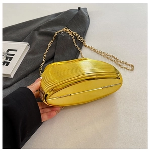 Detail of a gold metallic evening clutch with wavy stripes and a thin metal chain strap
