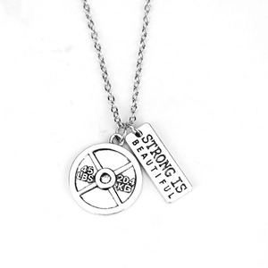 Silver dumbbell pendant necklace with Strong Is Beautiful tag and 45 lbs barbell plate