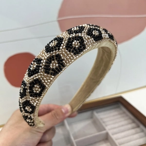 Detailed close-up of handmade leopard print headband with intricate gold bead embroidery