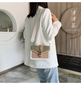 Detail of color-block crossbody bag with gold buckle on a model in a cafe setting