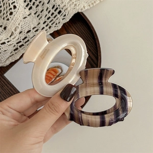 French style cream and purple oval claw clips displayed on a wooden tray with lace