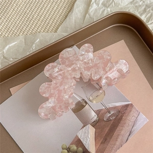 Detailed macro view of pink marble acetate hair claw clip with elegant wavy design