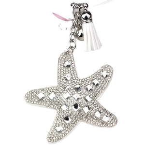 Close-up of sparkling rhinestone starfish keychain with white tassel and silver bell