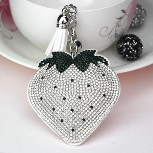 Detail of strawberry keychain with white rhinestones, silver alloy chain and white tassel