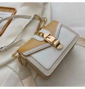Detail of contrast color square bag with gold buckle and wide woven shoulder strap