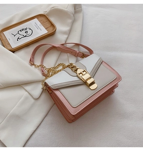 Detailed view of pink and white PU leather crossbody bag with gold chain and clasp