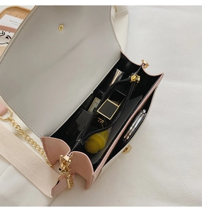 Top view of open white and pink crossbody bag showing interior capacity and golden chain